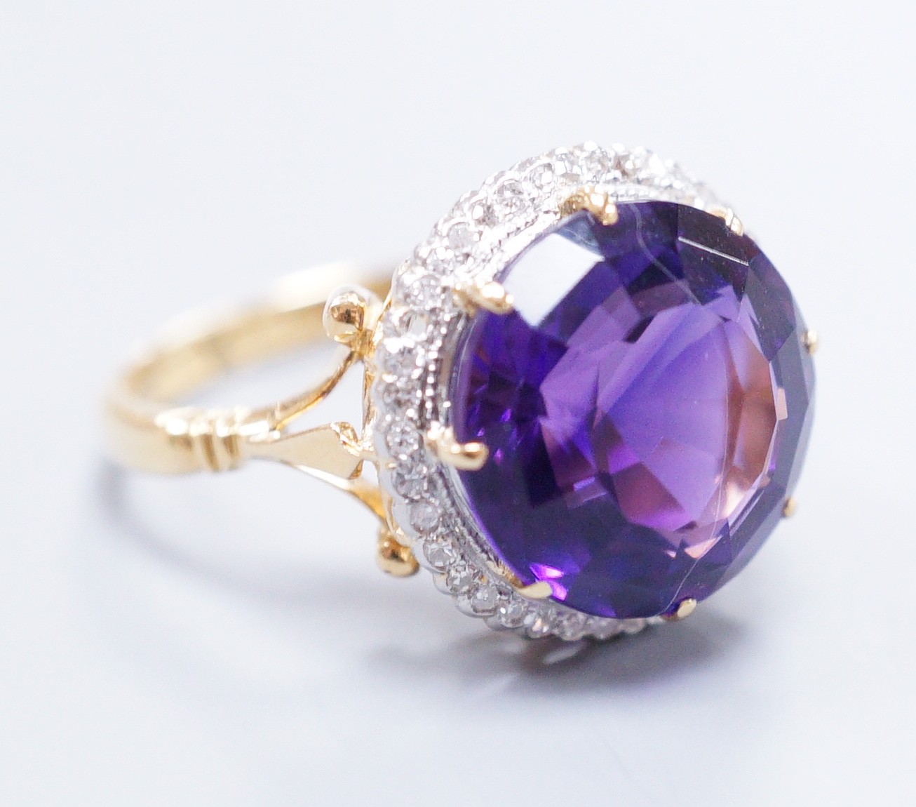 An 18ct gold and platinum, amethyst and diamond circular cluster ring, size M, gross 5.7 grams
